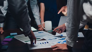 Business men and women meeting around table